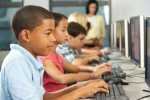Kids at keyboards in a computer lab.